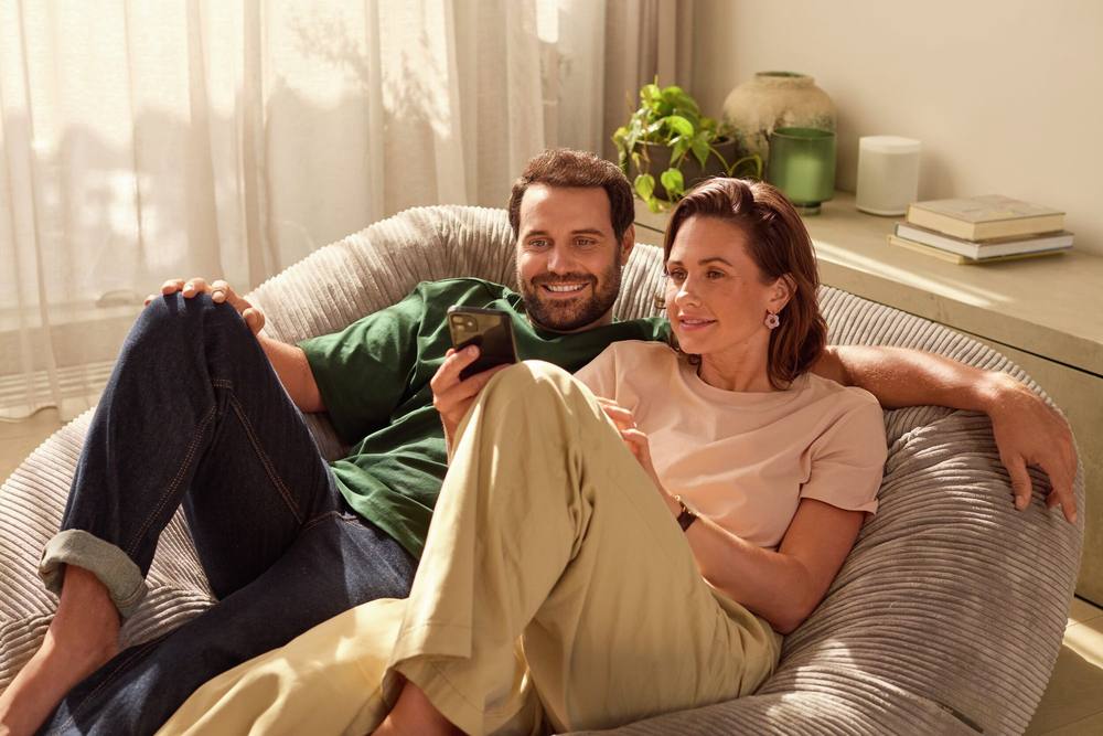Stel ontspant op de bank in een warme woonkamer